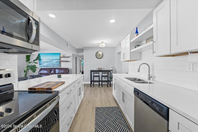 kitchen featuring white cabinets, stainless steel appliances, light hardwood / wood-style flooring, and sink