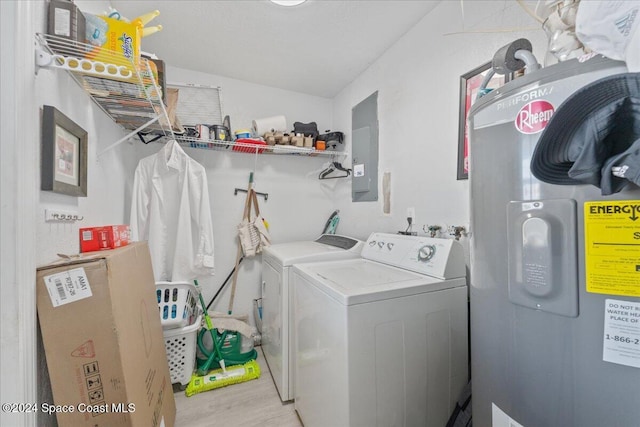 washroom featuring electric panel, electric water heater, washer and clothes dryer, and light hardwood / wood-style floors