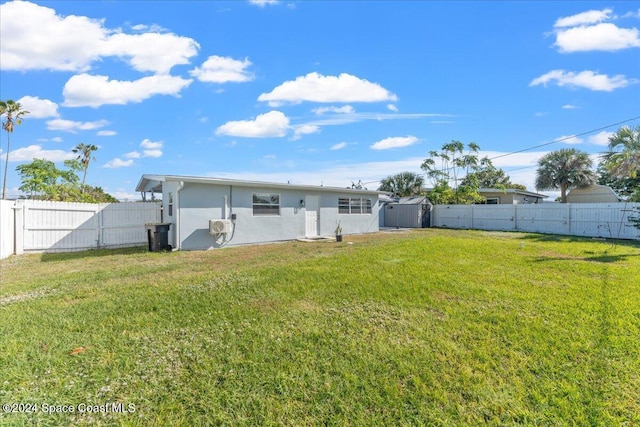 back of house with a lawn and a storage unit