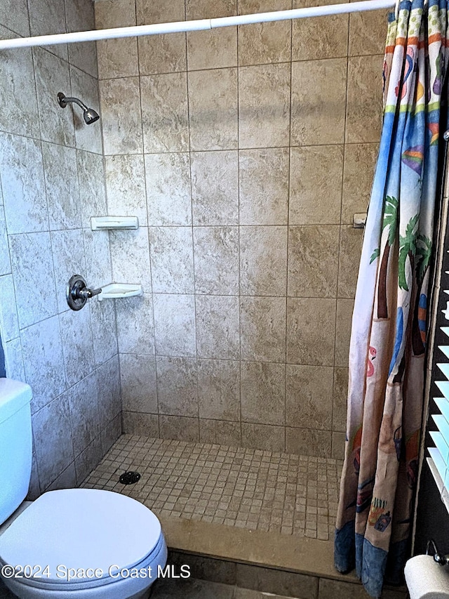 bathroom featuring a shower with shower curtain and toilet