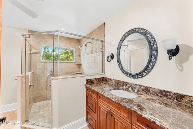 bathroom with vanity, ceiling fan, and a shower with door