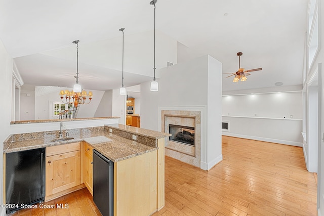 kitchen featuring light brown cabinets, black appliances, ceiling fan with notable chandelier, light wood-type flooring, and a fireplace