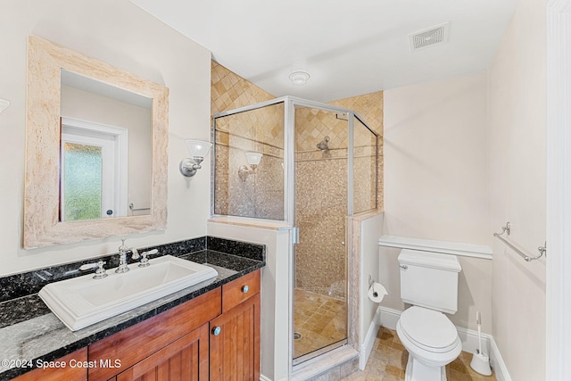 bathroom featuring vanity, toilet, and a shower with door