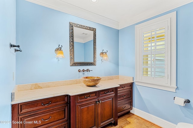 bathroom featuring hardwood / wood-style floors, vanity, and ornamental molding