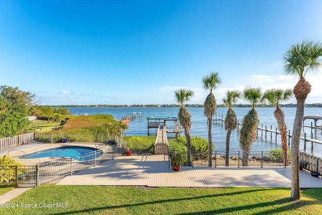 view of pool with a yard, a water view, and a patio