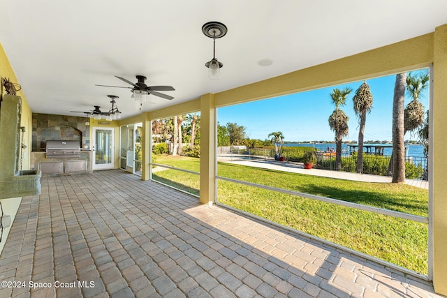 view of patio / terrace with an outdoor kitchen, a water view, area for grilling, and ceiling fan