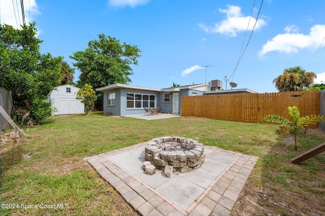 view of yard with a patio, an outdoor fire pit, a storage shed, and central air condition unit