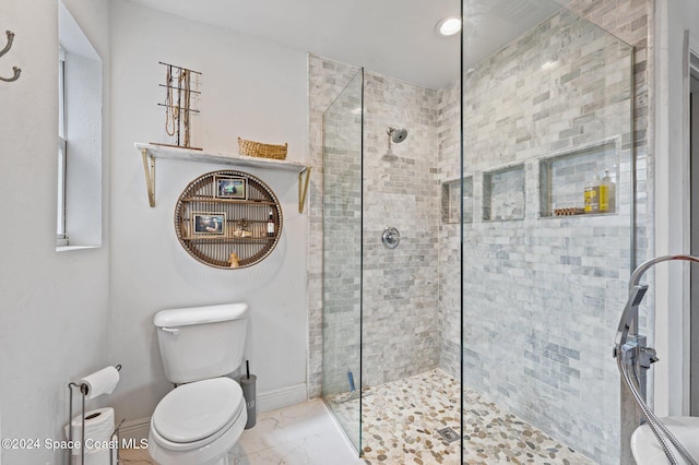 bathroom with tiled shower and toilet