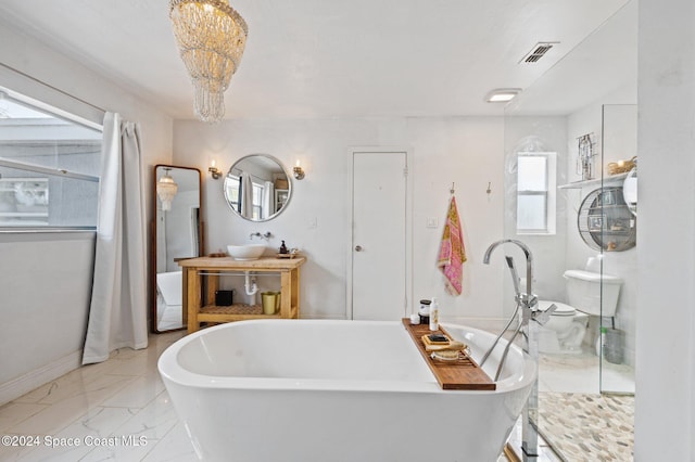 bathroom featuring sink, a tub to relax in, and a chandelier