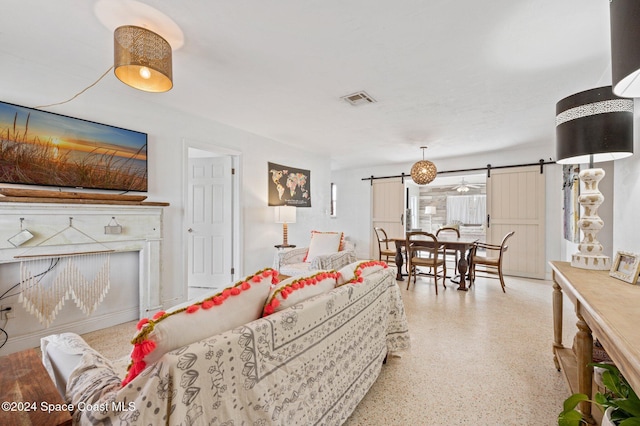 living room featuring a barn door and ceiling fan