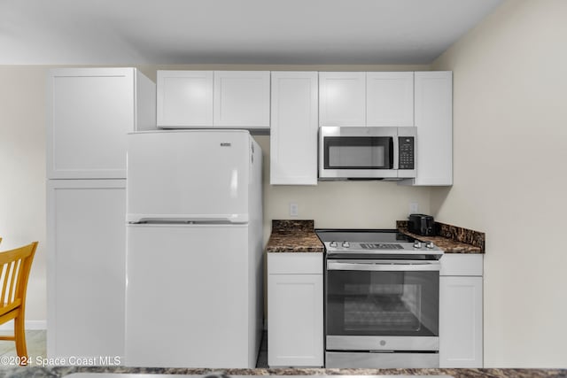 516 S Plumosa St Unit 20, Merritt Island, FL 32952 - kitchen featuring stainless steel appliances, white cabinets, and dark stone countertops