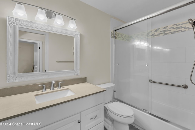 full bathroom featuring vanity, toilet, and bath / shower combo with glass door