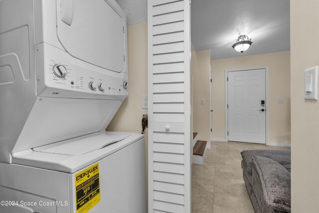 516 S Plumosa St Unit 20, Merritt Island, FL 32952 - laundry room with estacked washer and dryer and light tile patterned flooring
