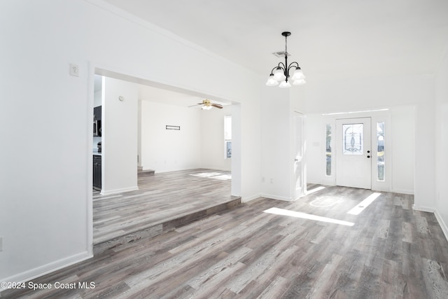 entrance foyer featuring ceiling fan with notable chandelier and wood-type flooring