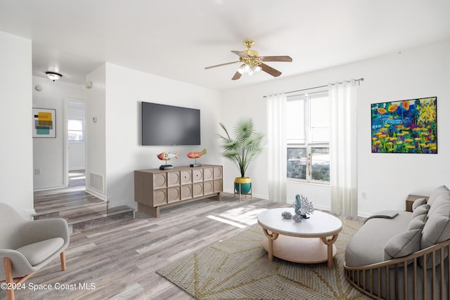 living room featuring light hardwood / wood-style flooring, a wealth of natural light, and ceiling fan