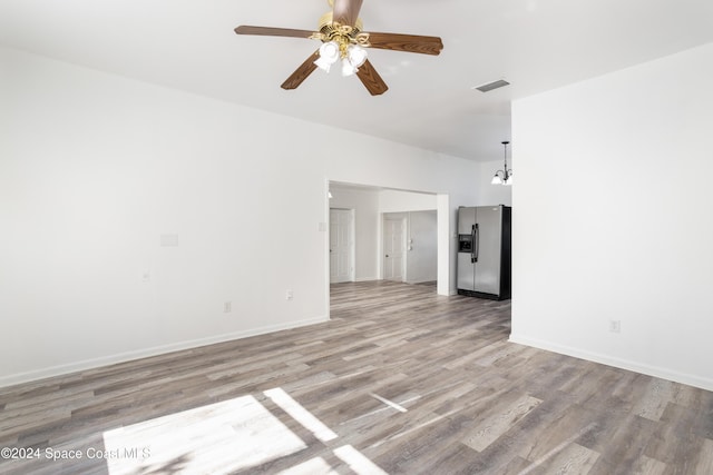 unfurnished living room with light hardwood / wood-style flooring and ceiling fan with notable chandelier