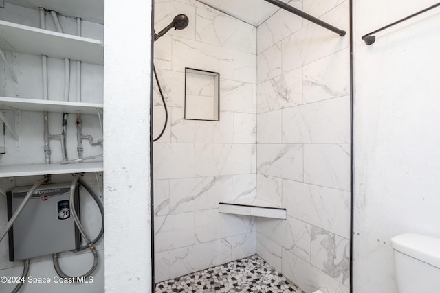 bathroom featuring toilet and tiled shower