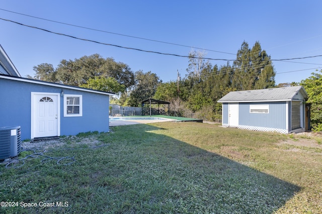 view of yard featuring central AC unit and a storage shed