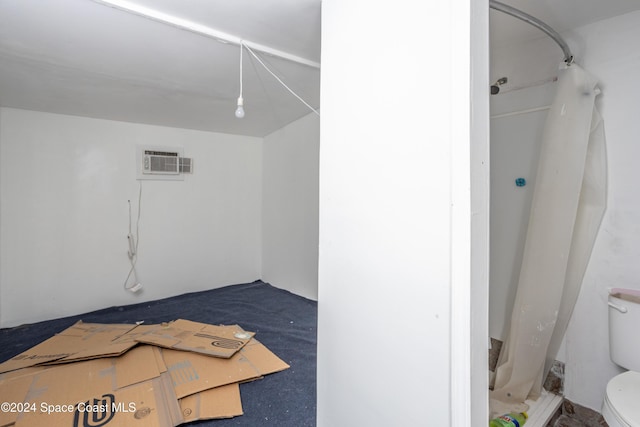 interior space featuring a shower with curtain and toilet