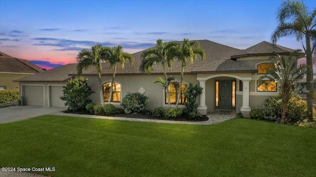 view of front of house featuring a lawn and a garage