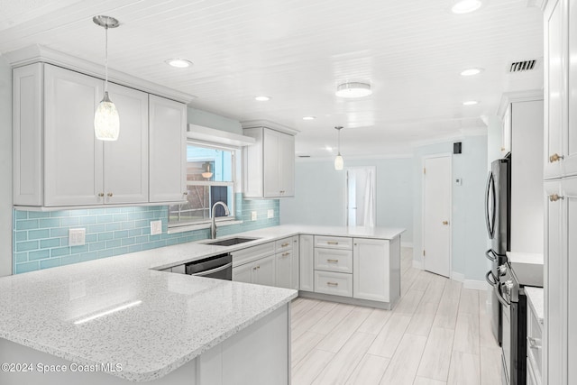 kitchen featuring kitchen peninsula, pendant lighting, white cabinetry, and sink