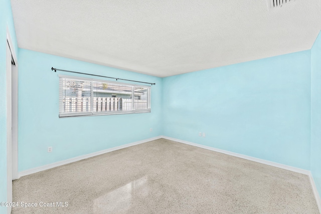 unfurnished room with a textured ceiling