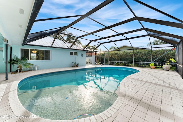 view of pool featuring glass enclosure and a patio area