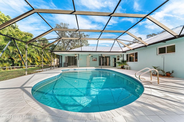 view of swimming pool featuring a patio area, ceiling fan, and a lanai