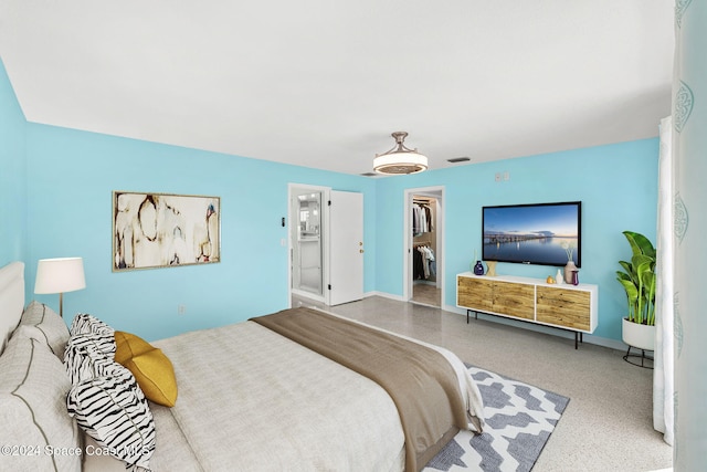 bedroom featuring ensuite bath, a spacious closet, a closet, and ceiling fan