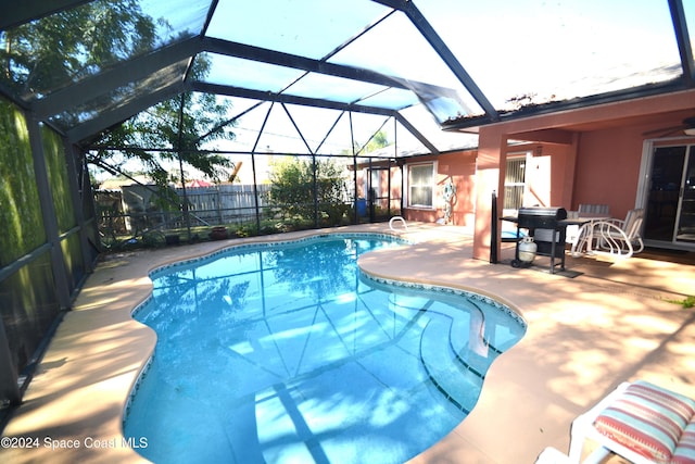 view of swimming pool featuring glass enclosure and a patio area