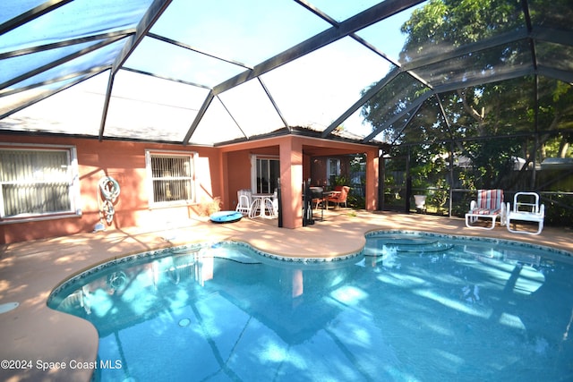 view of swimming pool featuring glass enclosure and a patio area