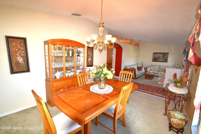 carpeted dining space featuring a textured ceiling, lofted ceiling, and a notable chandelier