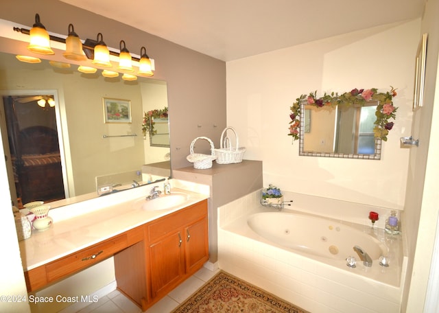 bathroom with tiled tub, tile patterned flooring, and vanity