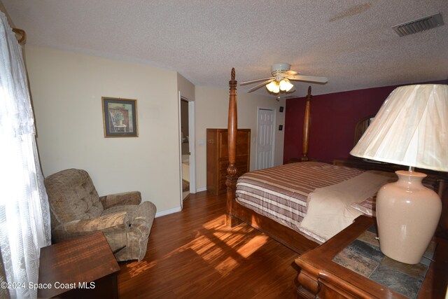 bedroom featuring a closet, a textured ceiling, dark hardwood / wood-style floors, and ceiling fan