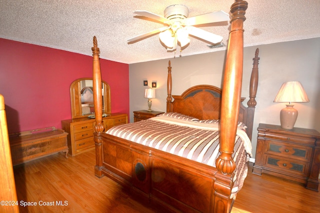 bedroom with a textured ceiling, light wood-type flooring, and ceiling fan