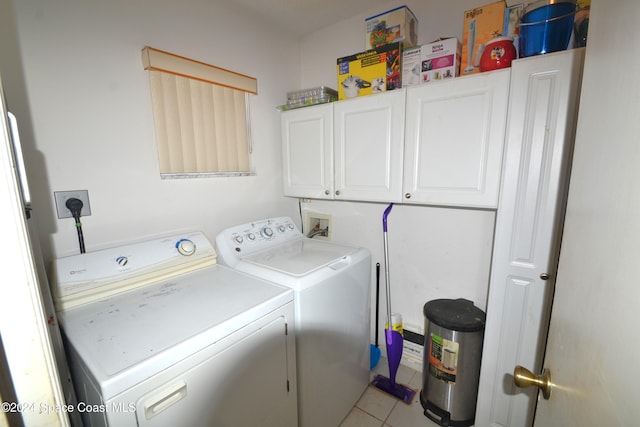 laundry room with cabinets, washing machine and dryer, and light tile patterned floors