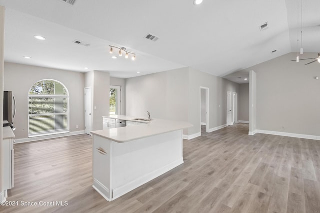 kitchen with sink, vaulted ceiling, ceiling fan, an island with sink, and light hardwood / wood-style floors