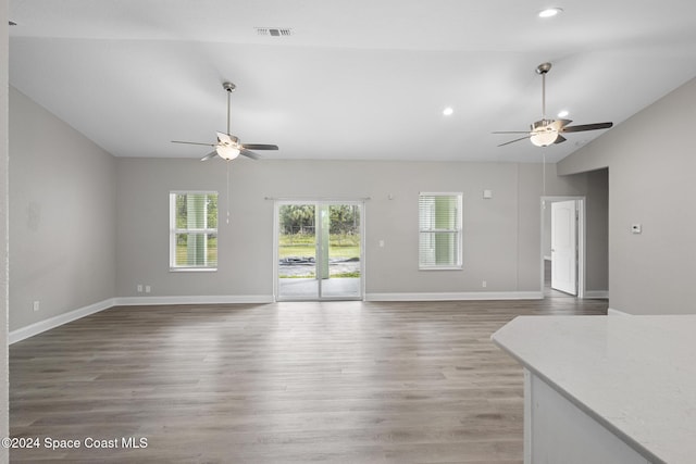 unfurnished living room featuring vaulted ceiling, ceiling fan, and dark hardwood / wood-style floors