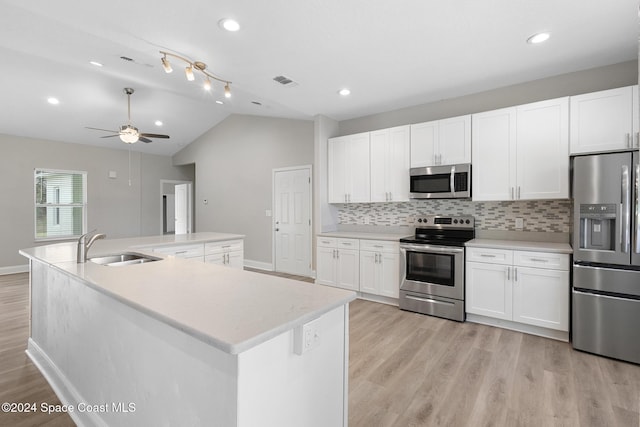 kitchen featuring sink, lofted ceiling, an island with sink, and appliances with stainless steel finishes