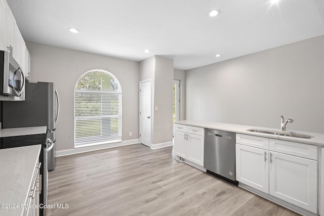 kitchen with light hardwood / wood-style flooring, stainless steel appliances, white cabinetry, and sink