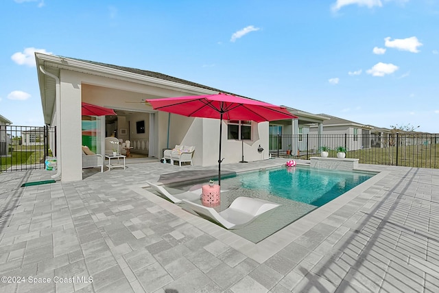 view of swimming pool with ceiling fan and a patio