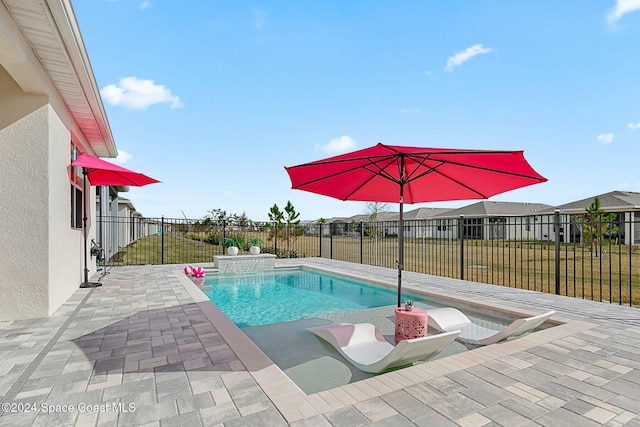 view of pool featuring a lawn, pool water feature, and a patio