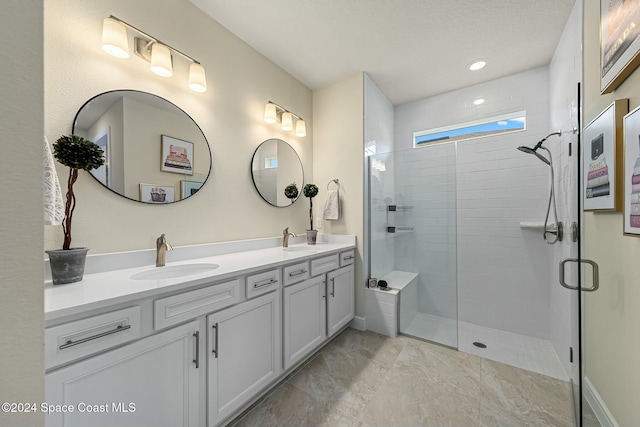 bathroom with a shower with door and vanity