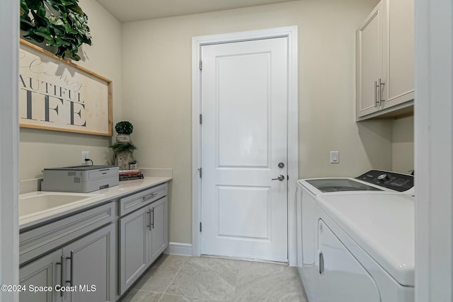 laundry area featuring cabinets, separate washer and dryer, and sink