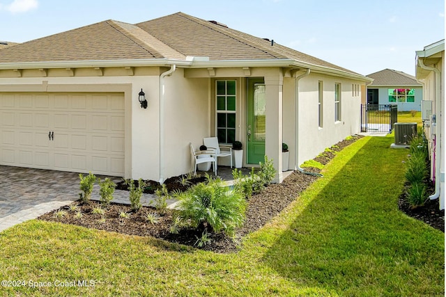 view of side of home featuring a lawn, central AC unit, and a garage