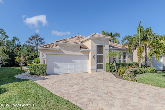 mediterranean / spanish house featuring a garage and a front lawn