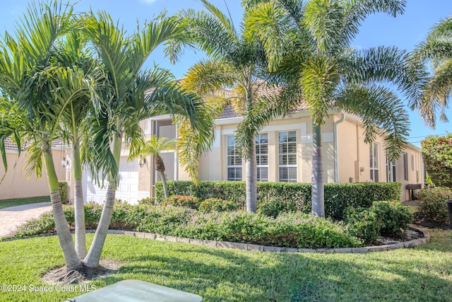 mediterranean / spanish-style home featuring a garage and a front yard