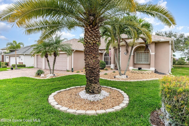 view of front of home with a front yard and a garage