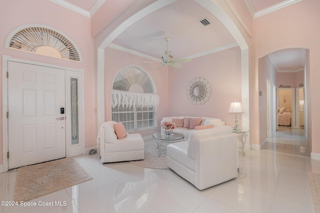 interior space featuring ceiling fan, crown molding, and a towering ceiling