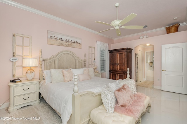 bedroom featuring ceiling fan, crown molding, and ensuite bathroom